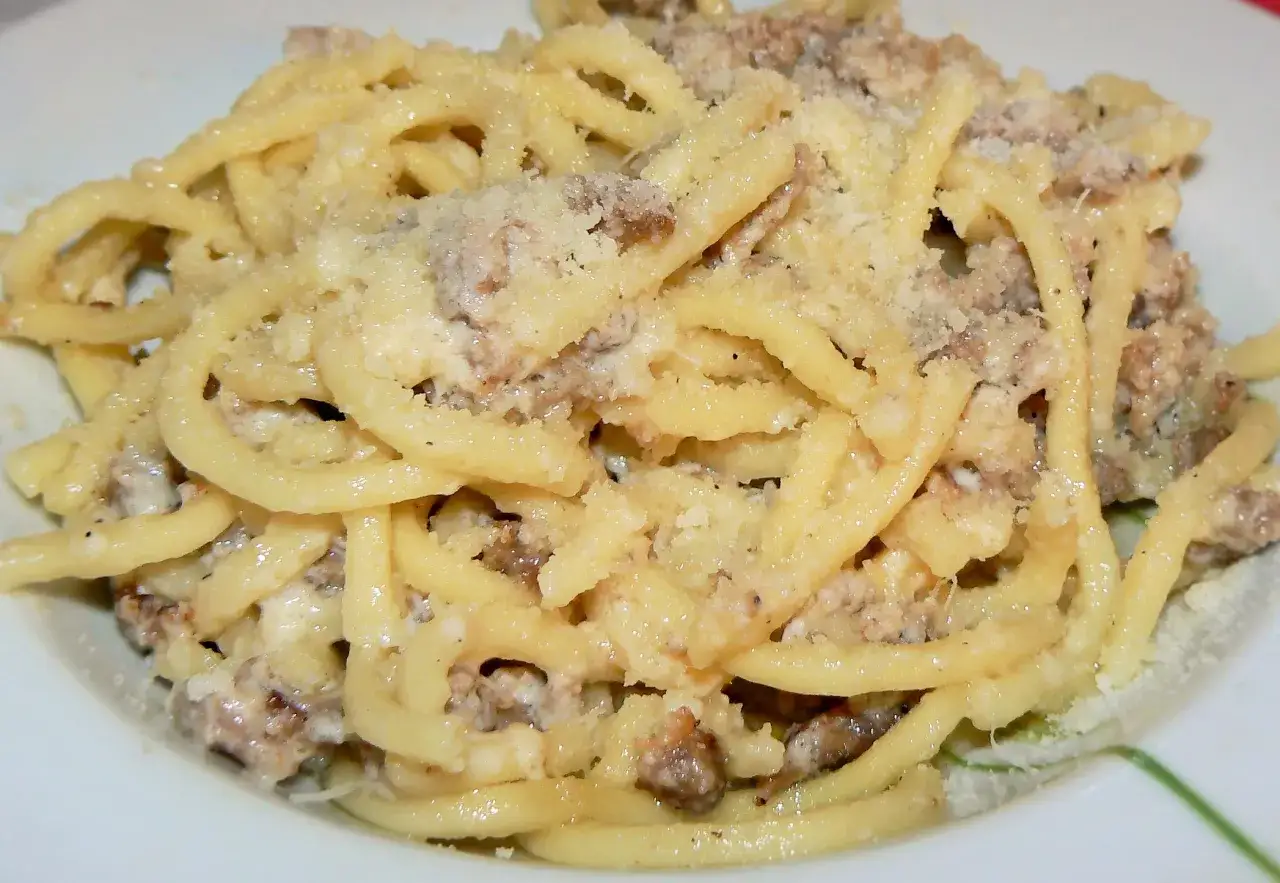 Un piatto fumante di umbricelli alla norcina, con salsiccia e formaggio grattugiato.