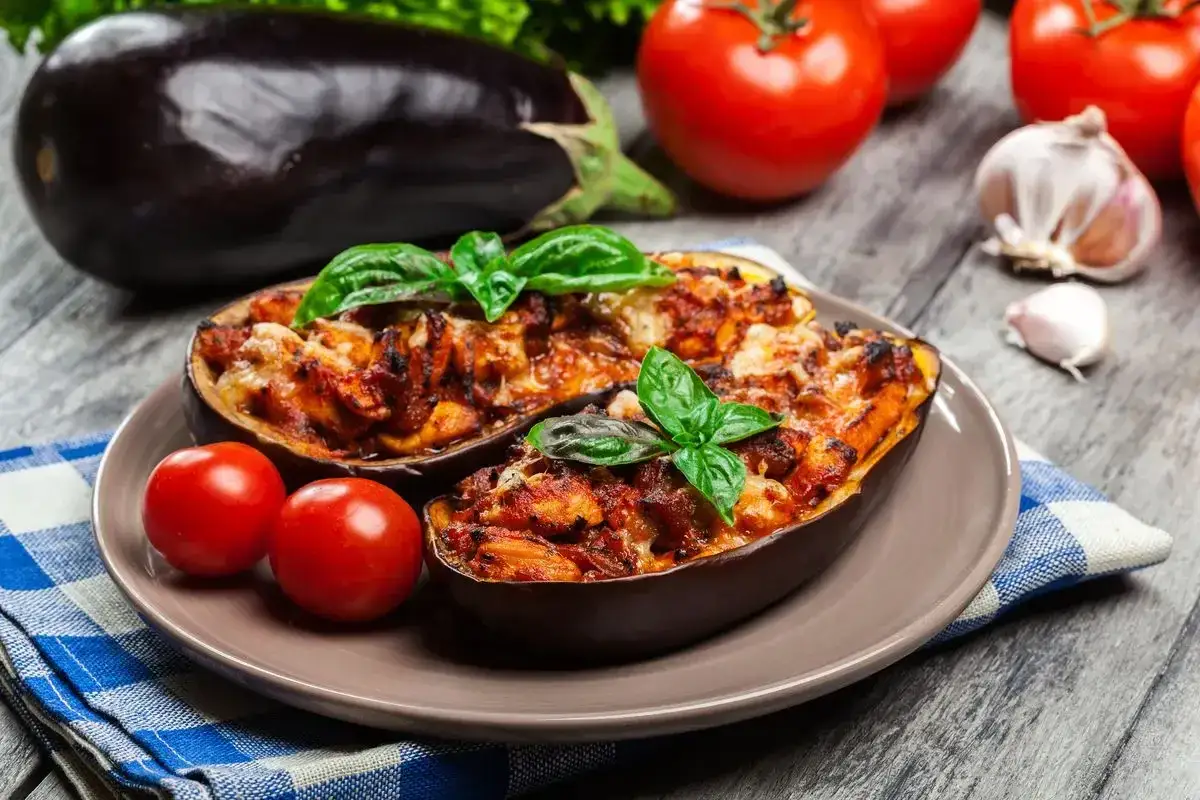 Melanzane ripiene vegetariane, un piatto gustoso e colorato, con pomodori freschi e basilico.