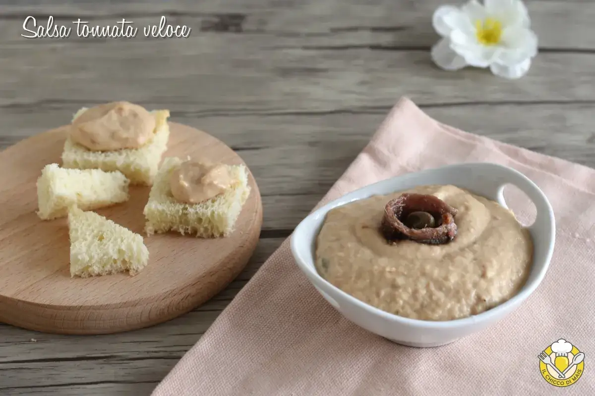 Salsa tonnata con maionese servita su cubetti di pane e in una ciotola con acciuga e capperi.