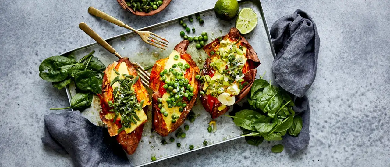Patate dolci al forno, farcite con piselli, spinaci e cipollotto. Un piatto colorato e salutare.