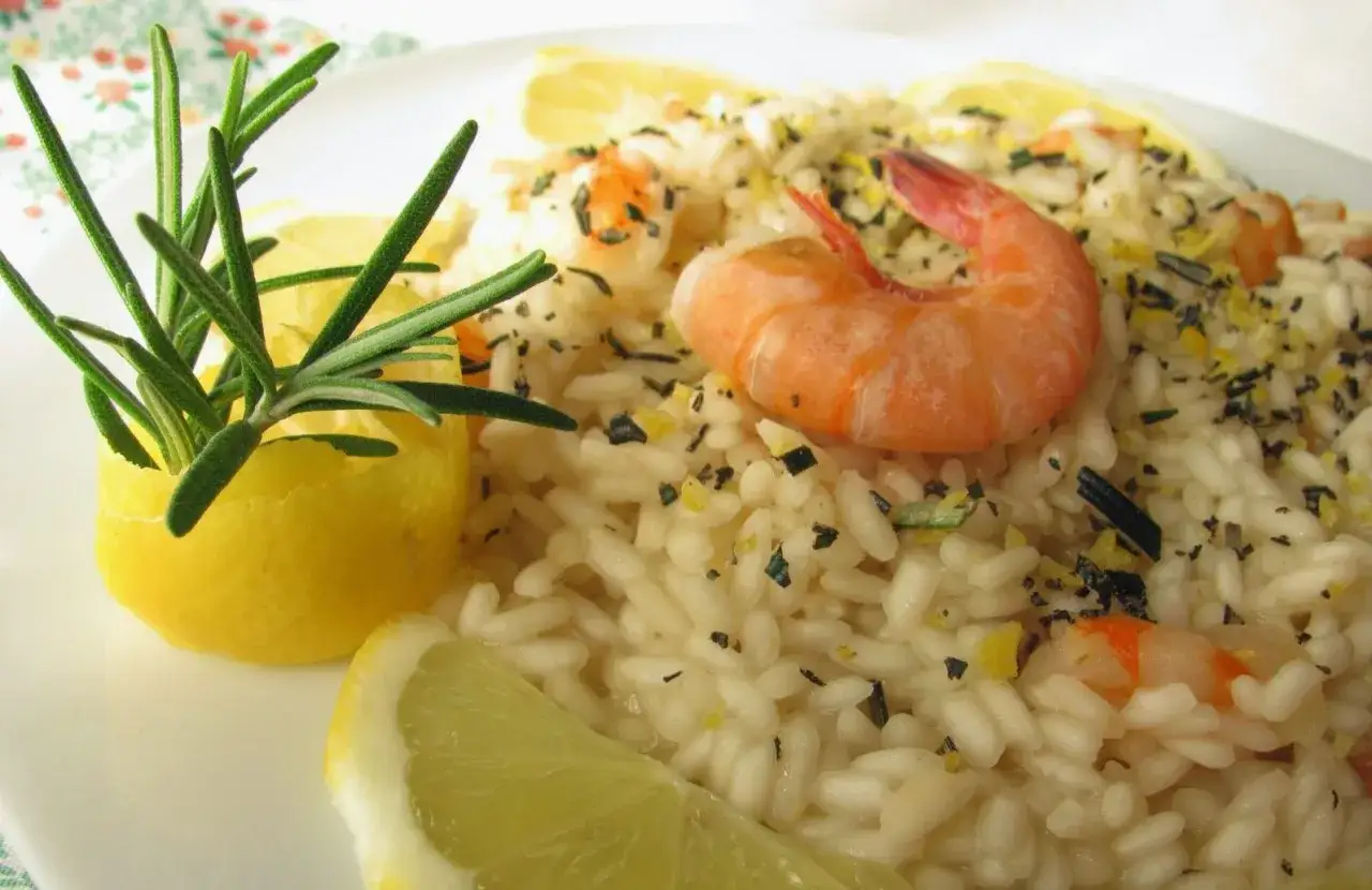 Deliziosa insalata di riso con gamberetti, guarnita con limone e rosmarino fresco. Un piatto leggero e saporito.